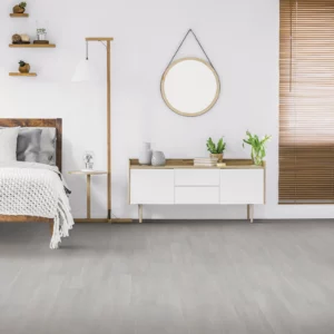 Gray luxury vinyl plank flooring in a bedroom | Coleman's Flooring & Blinds